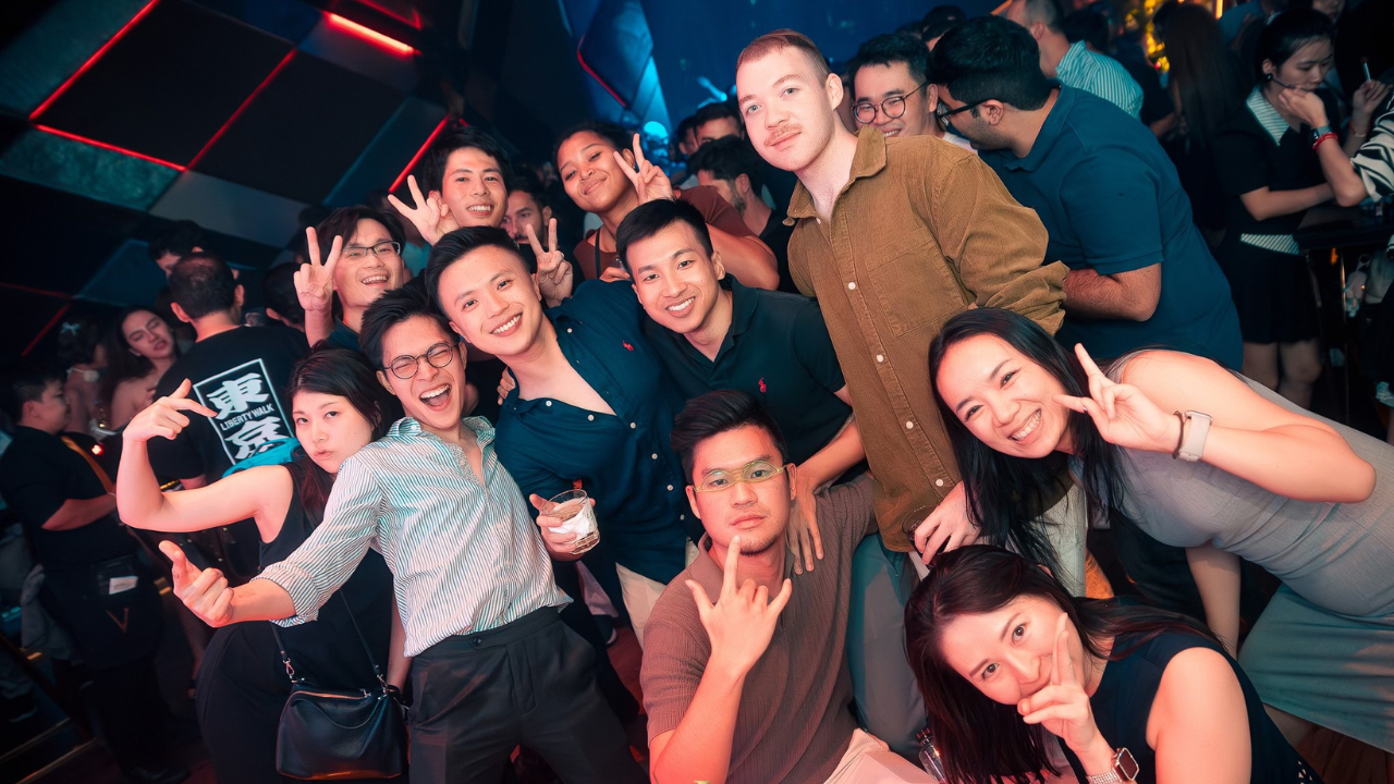 Vibrant neon lights and dancing crowd at a Bangkok party